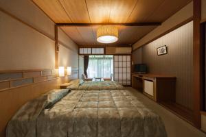 Säng eller sängar i ett rum på Onsen Guest House Aobato no Su