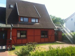 a red house with a metal roof at ton Timmermanns Hus in Prerow