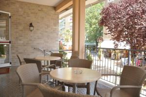 a restaurant with tables and chairs and a balcony at Albergo Larenzia in Cattolica