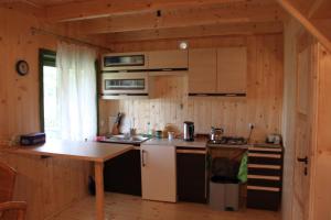 a kitchen in a log cabin with a table and a stove at Domek "U Magdy" in Sasino