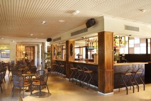 un restaurante con un bar con mesas y sillas en Luna Park Hotel Yoga & Spa, en Malgrat de Mar