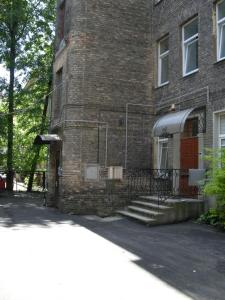 un edificio de ladrillo con una puerta roja y escaleras en Guest room in Old Town en Vilna