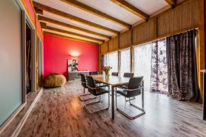 uma sala de jantar com paredes vermelhas e uma mesa e cadeiras em Villa Bach em Valgeranna