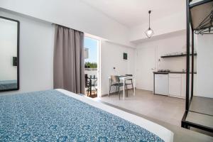 a bedroom with a bed and a kitchen and a table at Kappa Apartments in Faliraki