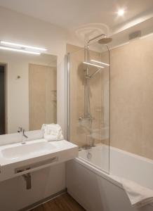ein weißes Bad mit einem Waschbecken und einer Dusche in der Unterkunft Résidence IFEC in Ivry-sur-Seine