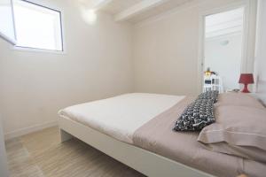 a bed in a white room with a window at Villa Del Mare in Alcamo Marina