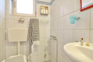 a white bathroom with a sink and a toilet at Studio Milo in Corfu