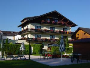 un gran edificio con mesas y sillas delante de él en Hotel Weismann en Sankt Georgen im Attergau