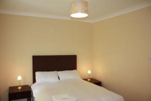 Desota House Bed and Breakfast في غالواي: غرفة نوم بسرير كبير مع مواقف ليلتين