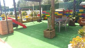 um parque infantil com escorrega, uma mesa e um baloiço em Villa Salteri em Benidorm