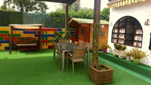 een patio met een tafel en stoelen en een huis bij Villa Salteri in Benidorm