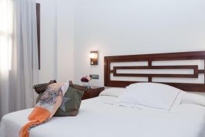 a bedroom with a white bed with a wooden headboard at Casa del Trigo in Santa Fe