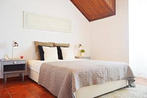 a white bedroom with a bed and a table at Belém Apartment in Lisbon