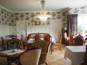 a dining room with tables and chairs and a chandelier at Pensionat Solhöjden in Mariannelund