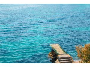 a bench sitting on the edge of a body of water at IDRO Studio Apartments directly at the beach in Split