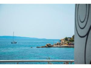 a boat in a body of water with a beach at IDRO Studio Apartments directly at the beach in Split