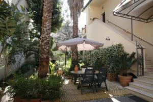 a patio with a table and chairs and an umbrella at Residenza D'Epoca B&B Celeste in Caserta
