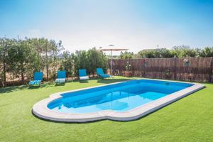 een zwembad in een tuin met blauwe stoelen bij Shostalet in Montuiri