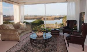 a living room with a couch and chairs and a large window at Cinnamon House Bed & Breakfast in Cape Town
