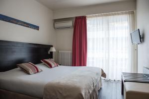Postel nebo postele na pokoji v ubytování Hôtel Comté de Nice