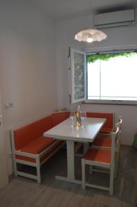 una mesa y sillas con una mesa blanca y una ventana en Apartment Toncica, en Omiš