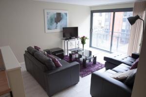 a living room with two couches and a tv at East Village City Center Luxury Apartment in Liverpool