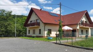 una casa con techo rojo y valla en Niezapominajka, en Lądek-Zdrój