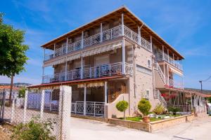 Un edificio de apartamentos con balcones y una valla. en Villa Ioanna, en Potos