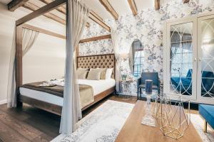 a bedroom with a canopy bed and floral wallpaper at Sala Resort Plateliai & SPA in Plateliai