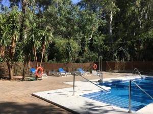 a swimming pool with two chairs and a swing at Hotel del Balneario in Tolox