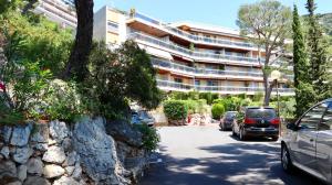 a parking lot with cars parked in front of a building at Les Jardins de Villefranche in Villefranche-sur-Mer