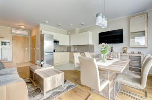 uma cozinha e sala de estar com mesa e cadeiras em Sun&Sea - Tremare Residence em Gdansk