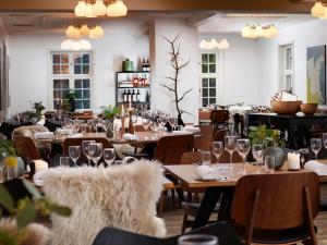 a restaurant with tables and chairs with wine glasses at Skarrildhus Sinatur Hotel & Konference in Skarrild