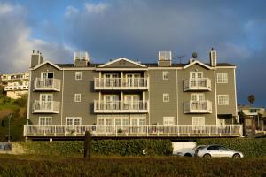 un gran edificio de apartamentos con un coche aparcado delante de él en Inn at Playa del Rey en Los Ángeles