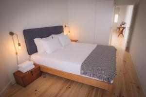 um quarto com uma cama grande e lençóis brancos em Bonfim 234 Townhouse no Porto