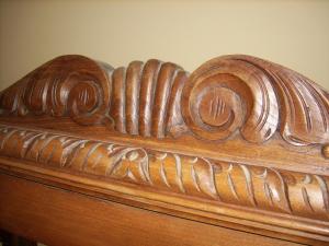 een houten hoofdeinde van een bed met houtsnijwerk bij Pension Txomin Ostatua in Etxebarria