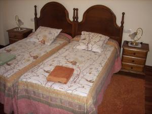 a bed with a wooden headboard and a purse on it at Pension Txomin Ostatua in Etxebarria