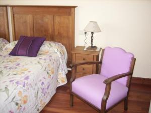 a bedroom with a bed and a chair and a lamp at Pension Txomin Ostatua in Etxebarria