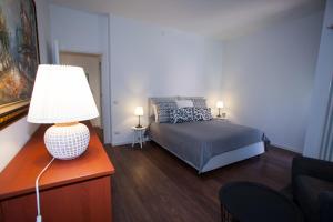 1 dormitorio con 1 cama y 1 mesa con lámpara en Oikos, en Matera