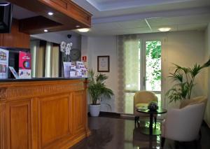 a lobby with a bar with chairs and a table at The Originals City, Hôtel Paris Sud, Orly-Draveil in Draveil