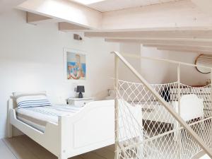 a white bedroom with a white bed and a swing at Portopiccolo Avolare Apartments in Borgo in Sistiana