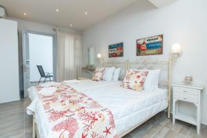 a bedroom with a white bed with red and white pillows at Relax Studios in Naxos Chora