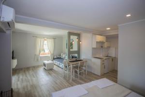 a kitchen and living room with a table and a desk at Apartments St Dimitrij in Ohrid