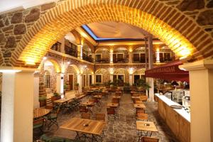 an empty restaurant with wooden tables and chairs at L'Agora Old Town Hotel & Bazaar in İzmir