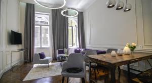 een woonkamer met een tafel en paarse stoelen bij Opera Apartment with FREE parking, 2BR2BA, AC in Boedapest