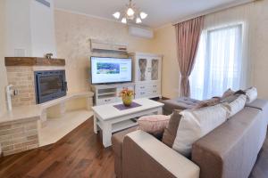 uma sala de estar com um sofá e uma televisão em Aqua Breeze Apartments em Budva