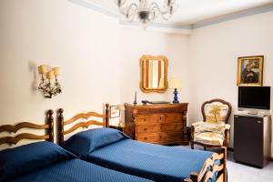 a bedroom with a blue bed and a dresser and a mirror at Residenza d'Epoca Albergo Quattro Fontane in Venice-Lido