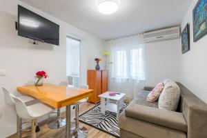 a living room with a couch and a wooden table at Apartments Roma in Baška Voda
