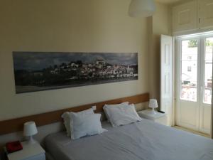 1 dormitorio con 1 cama y una pintura en la pared en Casa João Chagas Guesthouse, Constância, en Constância