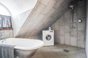 een badkamer met een bad en een wasmachine bij Karja Castle Apartments in Haapsalu